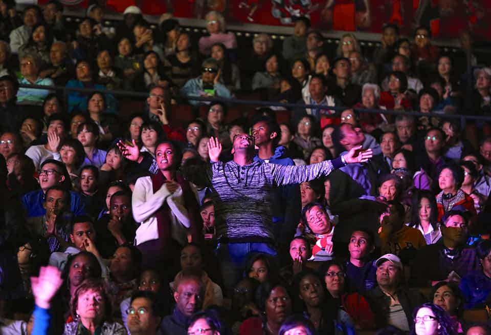 Man worshiping in crowd