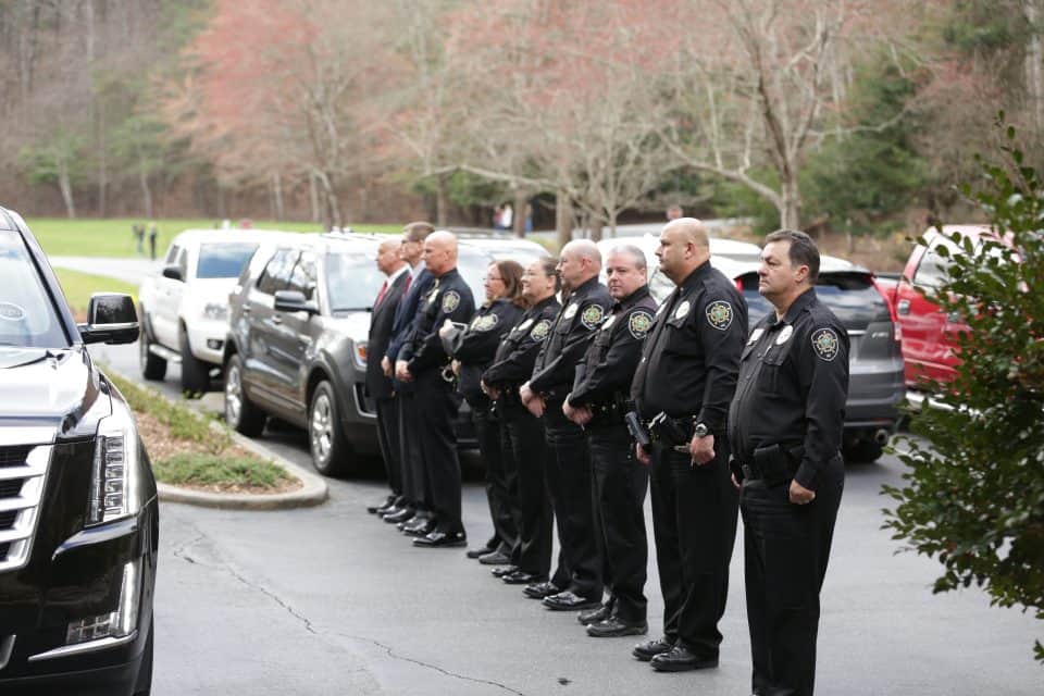 Law enforcement officers lined the driveway as the hearse left The Cove.