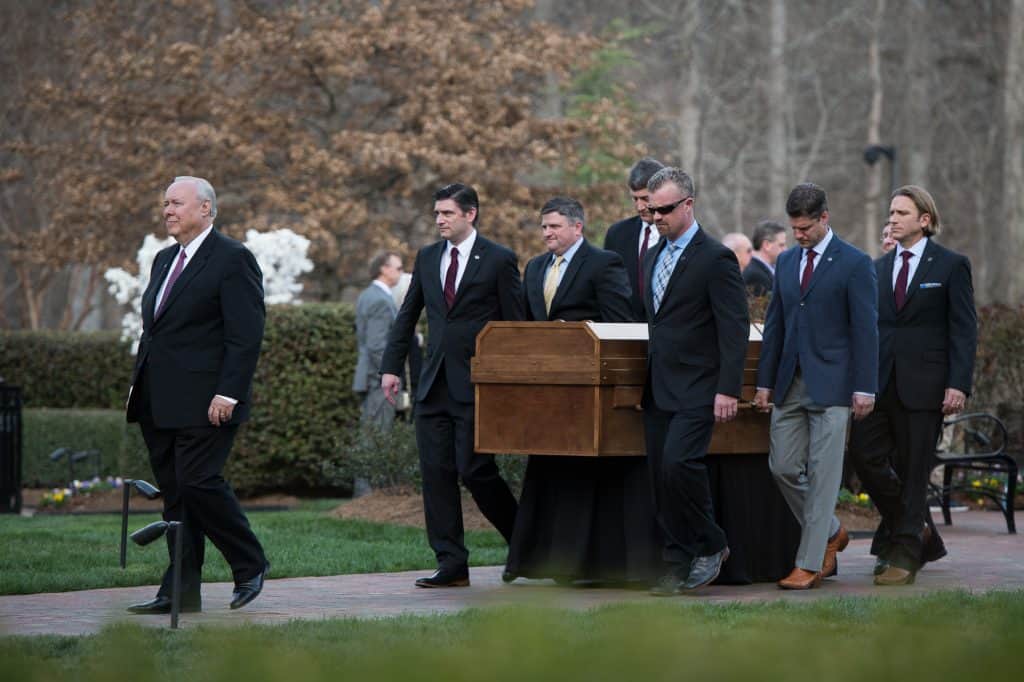 Billy Graham's grandsons, including Will Graham (pictured at the front of the casket in a red necktie) are serving as pallbearers. On Saturday, six of the 12 grandsons carried Mr. Graham into the Billy Graham Library for a private family ceremony.