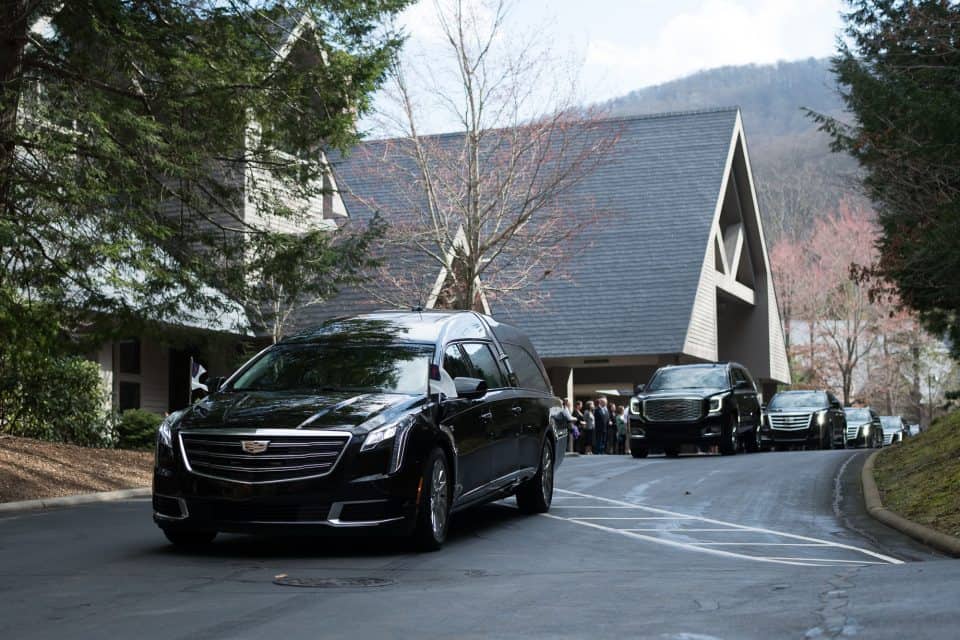 Billy Graham's hearse departed from The Cove around 11:30 a.m. Franklin and Jane Graham drove behind the hearse, followed by Billy Graham's daughters, Anne, Ruth, and Gigi, and their families. Many of Mr. Graham's grandchildren were also part of the procession.