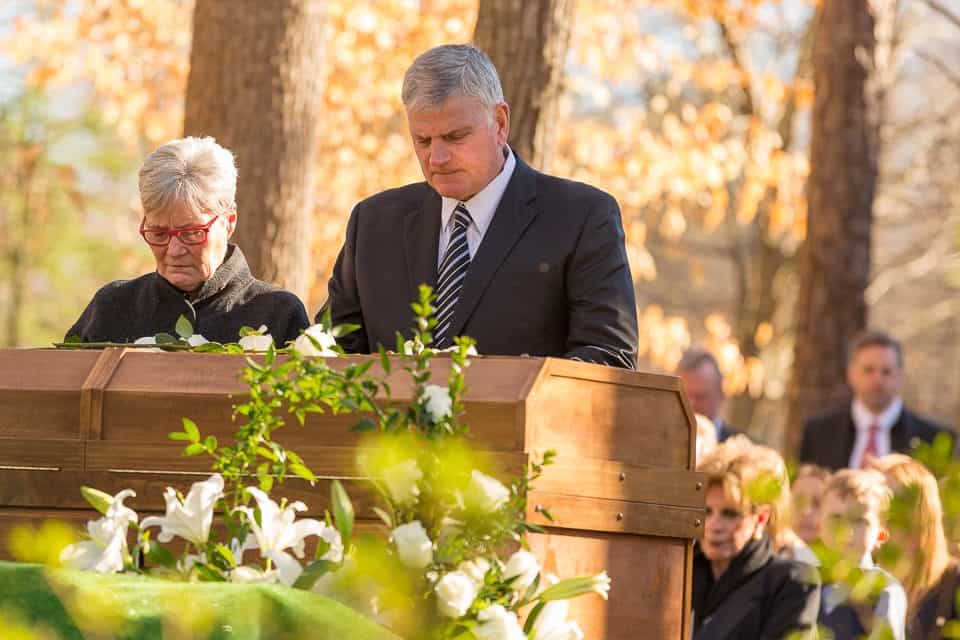 Franklin Graham pauses for a moment of prayer during the interment service.