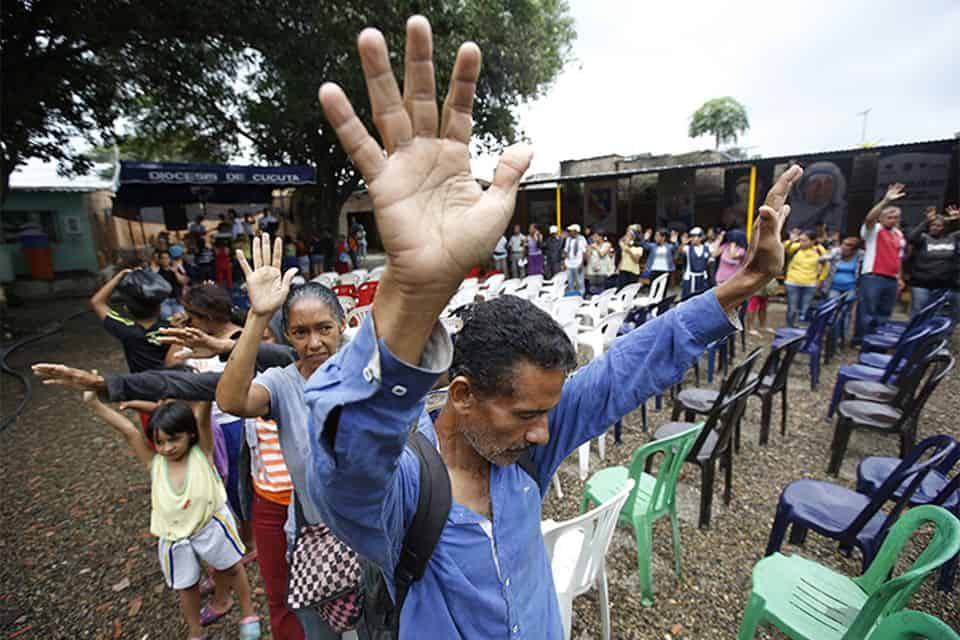 On April 19-20, Franklin Graham will preach the Good News in the border town of Cúcuta, Colombia. Here, Venezuelan migrants pray in the city. (AP Photo/Fernando Vergara)