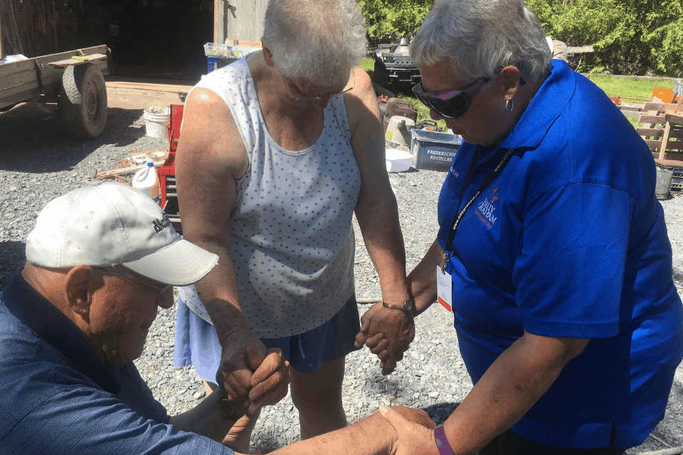 A crisis-trained Rapid Response Team chaplain prays with New Brunswick residents after flooding in 2018.