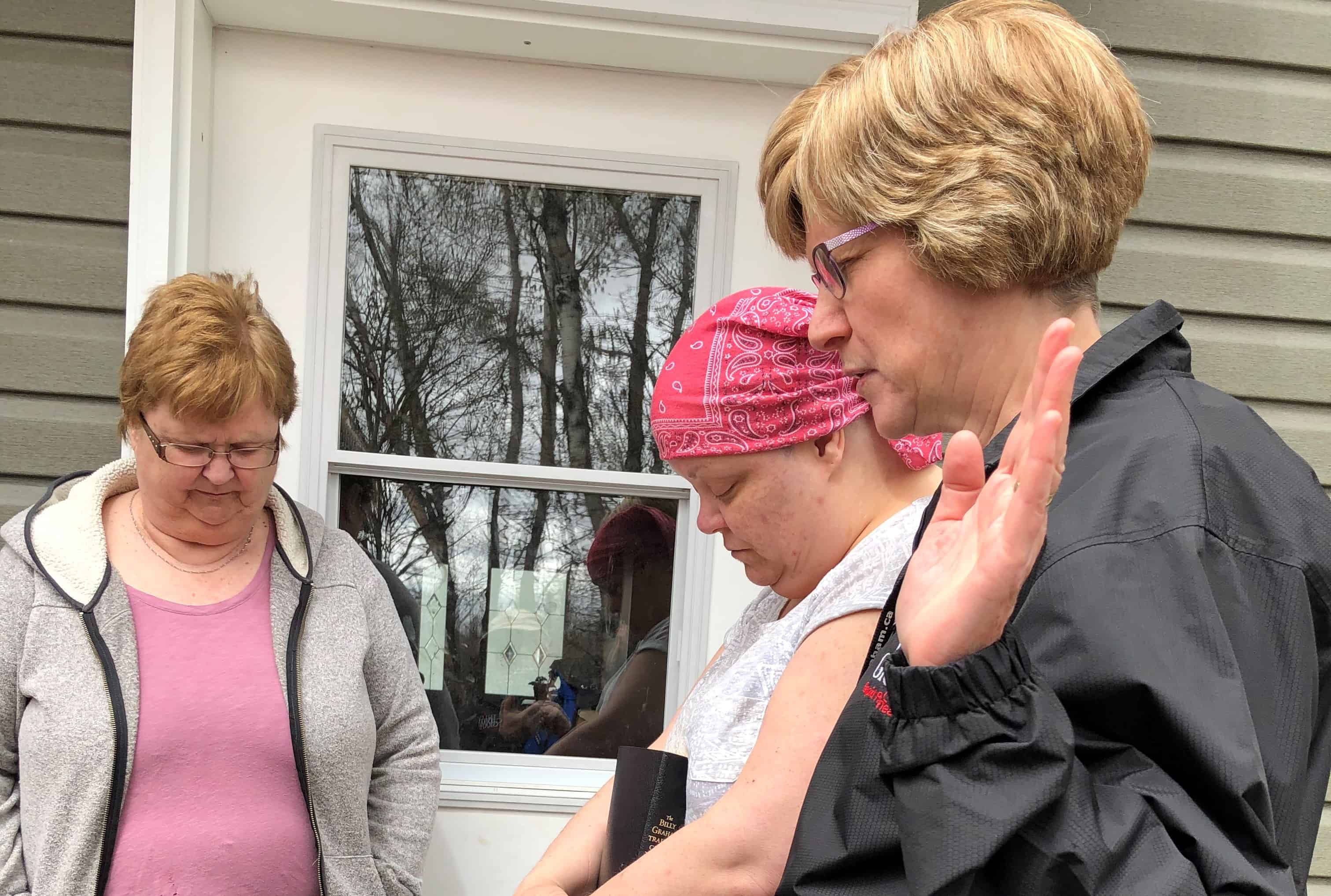 A Rapid Response Team chaplain prays with flood-effected residents in the New Brunswick community of Maugerville.