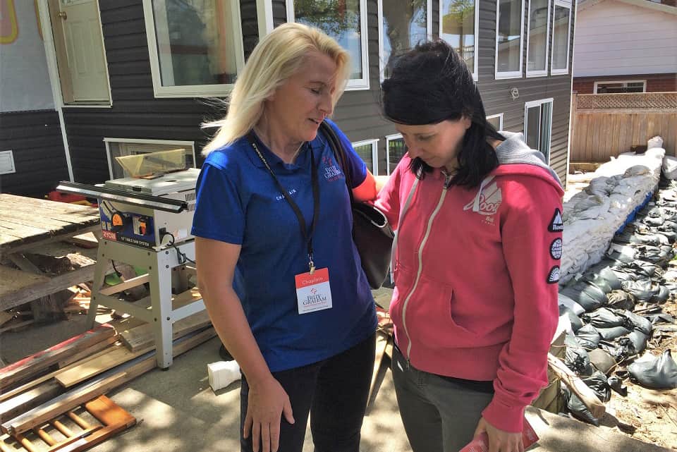 Our Rapid Response Team chaplain prays with an Ottawa flood victim whose home is undergoing sanitization and repairs from water damage.