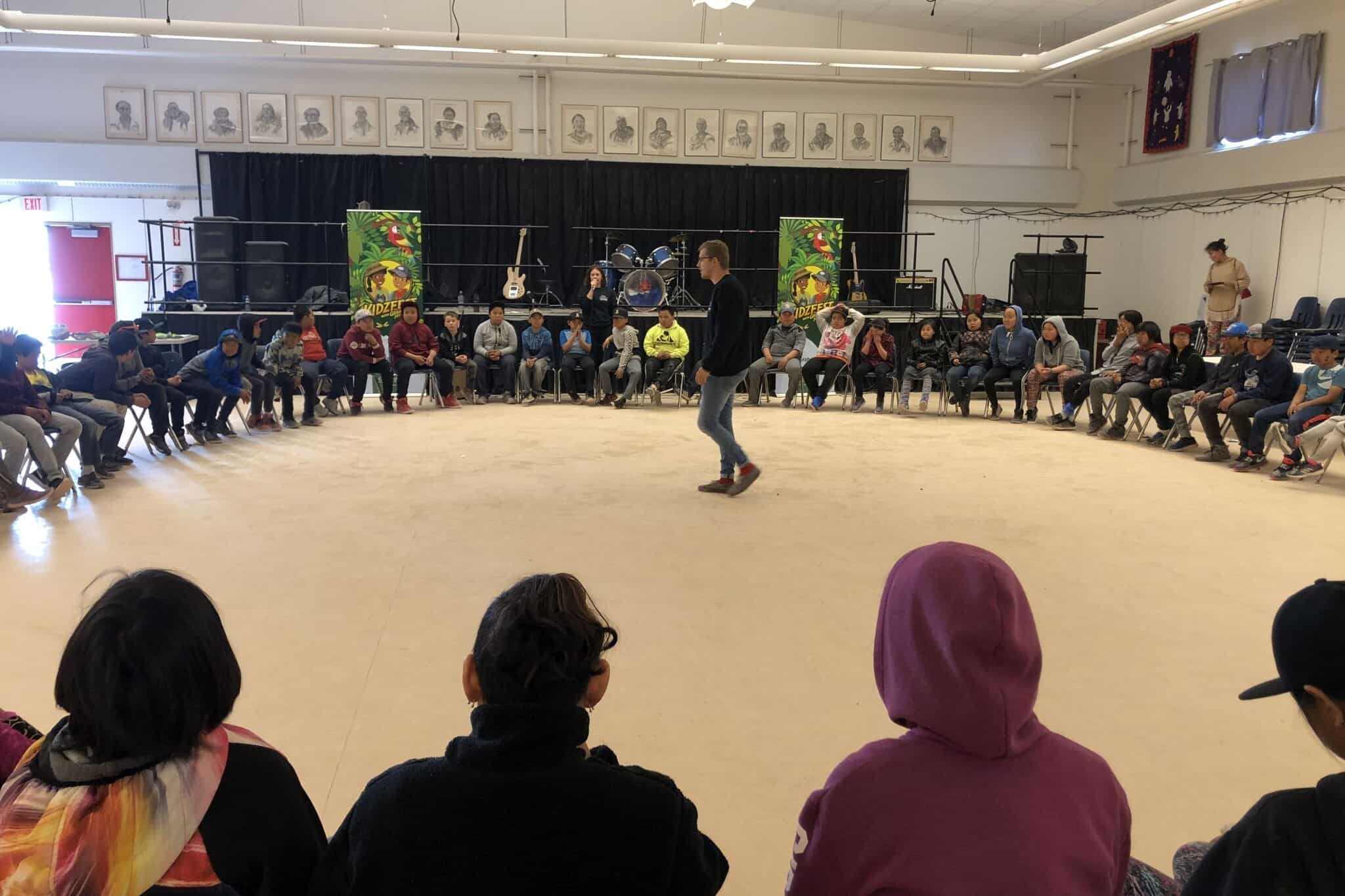 Youth gather around in a talking circle at Baker Lake KidzFest