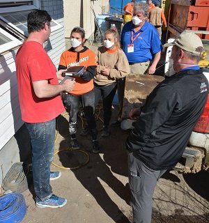 Lauren, a Samaritan’s Purse volunteer, presents a Bible to Jonathan, a flood victim, after she and RRT Chaplain Merle Doherty shared the Gospel with him.