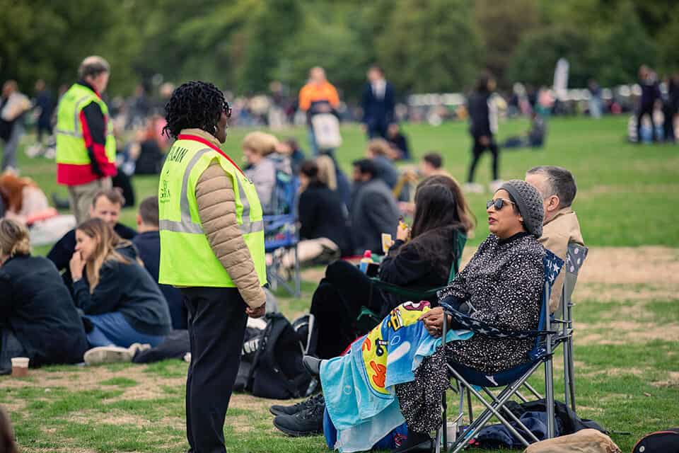 A Billy Graham chaplain talks with a woman at Hyde Park during the queen's funeral.