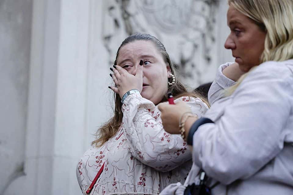 People seen crying at Buckingham Palace after the announcement of the death of Queen Elizabeth II. (AP Image)