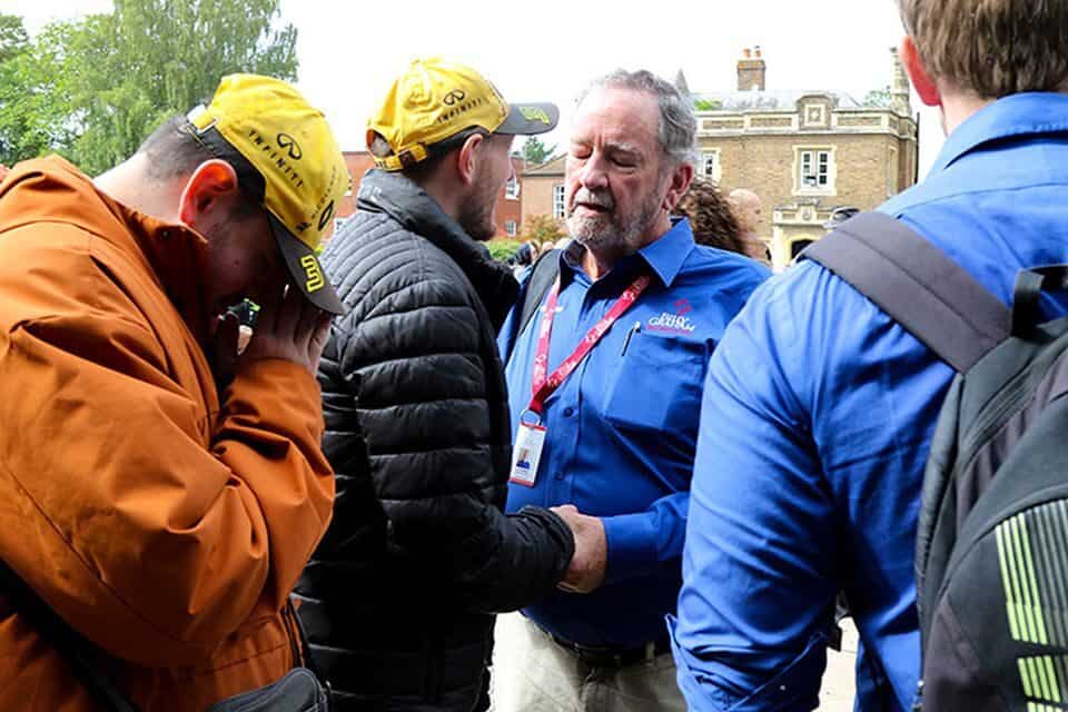 Chaplain John Magwood from the Billy Graham Rapid Response Team prays with men outside Windsor Castle following Her Majesty Queen Elizabeth II's death.