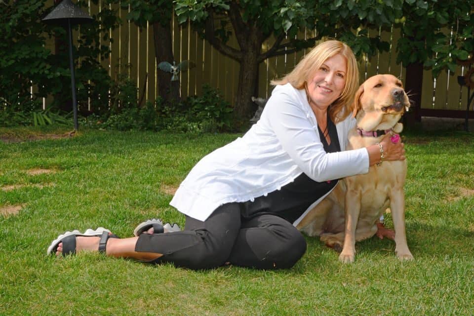 Former newspaper columnist Licia Corbella gets her dog, Bonnie, to calm down enough for a photo.