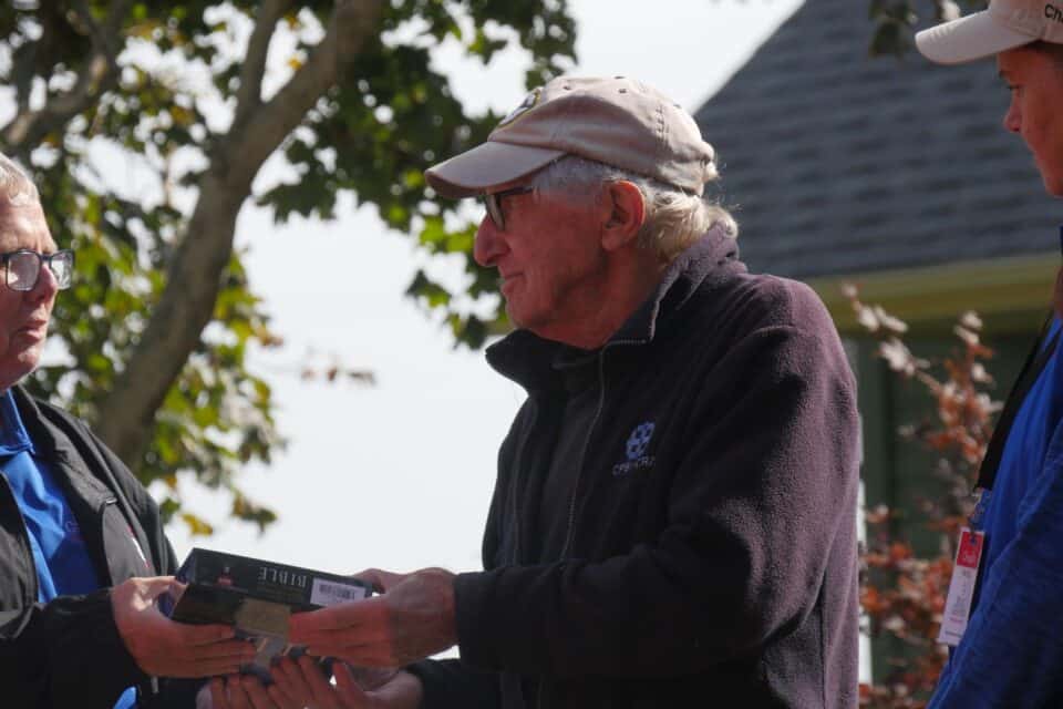 Chaplains present a homeowner with a Bible.