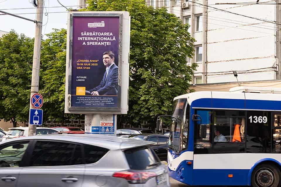 A billboard advertising this weekend's Will Graham Celebration of Hope in Chișinău stands along a busy road.