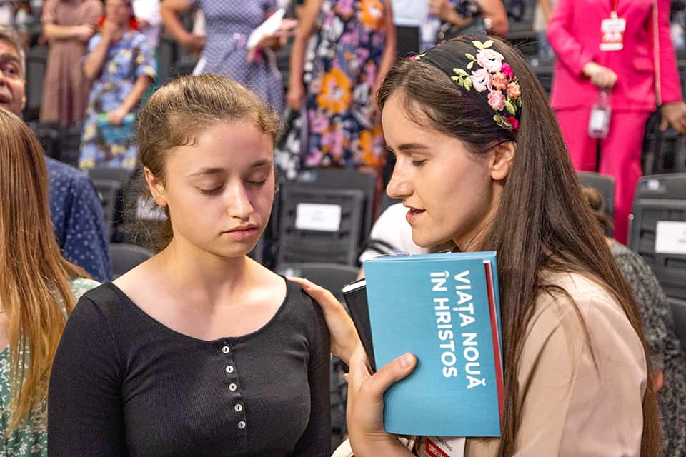 Woman praying with attendee.