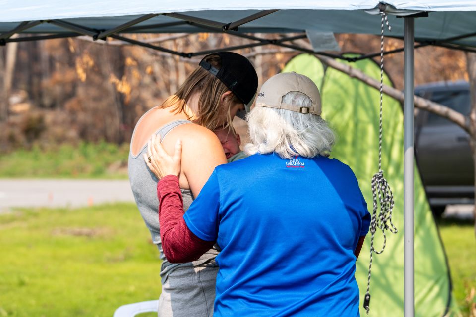 A chaplain encourages a young mom whose home was destroyed after the Wolf Fire tore through Denare Beach, Saskatchewan)